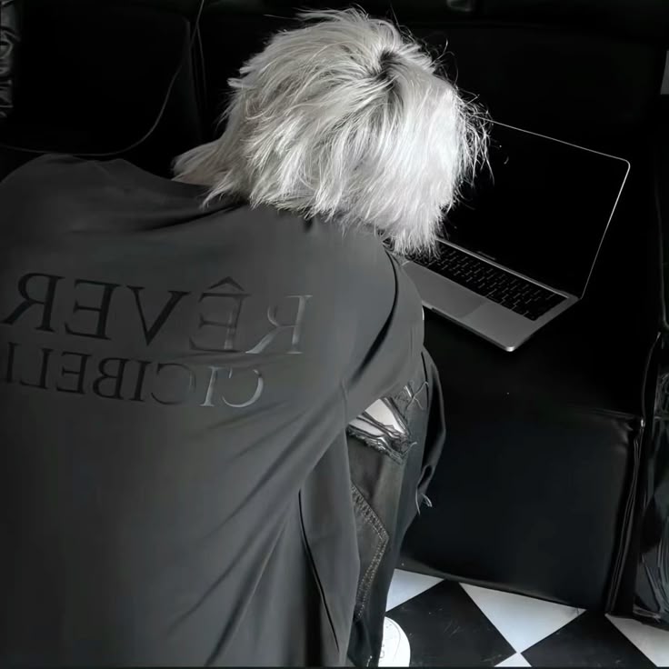 Profile picture showing someone with white hair from behind, working on a laptop